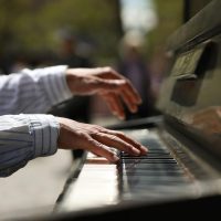 pexels-photo-32115816-32115816 An outdoors close-up photo showing hands playing the piano.